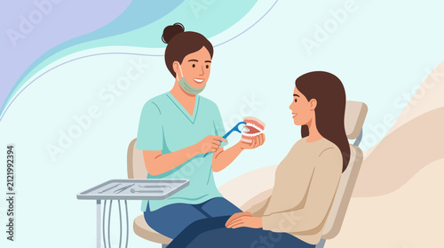 Dentist demonstrating dental hygiene with teeth model to patient