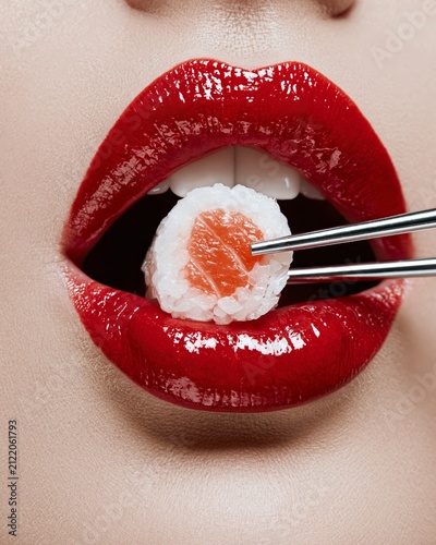 Red lips bite sushi with chopsticks
