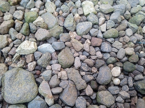 Bild auf Leinwand Natural River Stones and Pebbles Background Near a Residential House