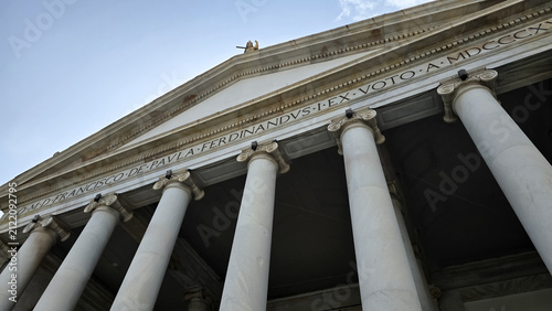Low angle perspective of the neoclassical portico and ionic columns of San Francesco di Paola in Piazza del Plebiscito, Naples, Italy.