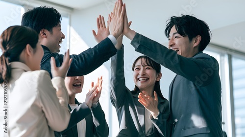 Serene team celebrating with a high five / 柔らかな光のハイタッチで喜ぶ職場チーム