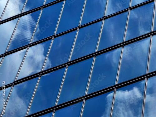 Konstfotografi Urban skyscraper with mirrorlike surfaces showcasing clouds and geometric patter
