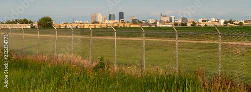 Fotografía Winnipeg skyline seen beyond airport perimeter fence and prairie grass, Manitoba
