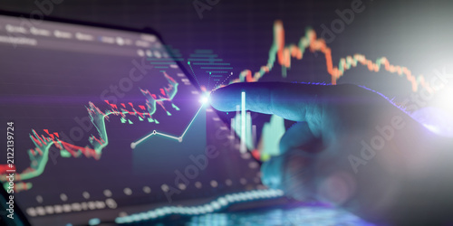 businessman finger touching a glowing futuristic tablet screen with financial trading charts and stock market growth data.