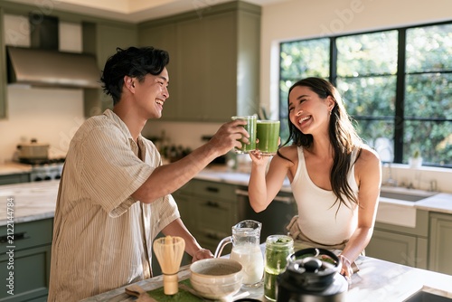 Young couple enjoying healthy drinks together in modern kitchen