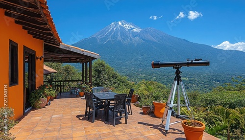 Orange villa patio views snowy volcano and lush green landscape. Ideal for travel, vacation, adventure, or scientific observation needs.