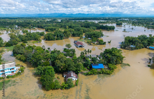 An aerial view shows floodwaters inundating homes, farmland, and trees in a rural area following heavy monsoon rainfall in Assam, India. Seasonal flooding submerged large parts of the landscape
