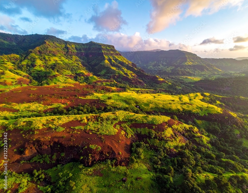 Obraz premium Aerial view of a lateritic Sahyadri plateau glowing with lush green vegetation, surrounded by rolling monsoon clouds.