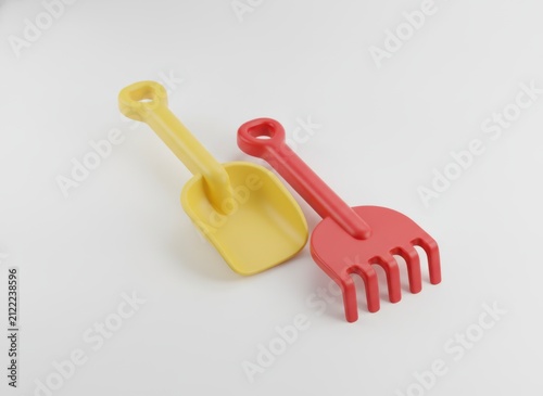 Yellow plastic shovel and red rake for sand play