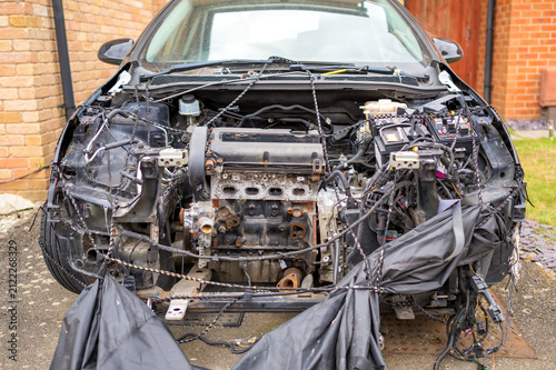 Dismantled car with exposed engine bay during repair
