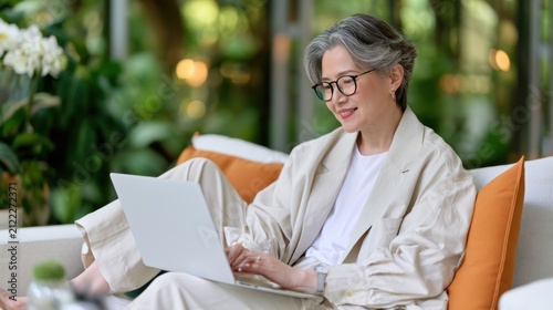 Mature businesswoman working on laptop in modern workplace