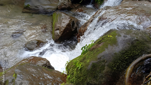 Obraz na plátně Flowing river waterfall cascading over wet mossy rocks in nature