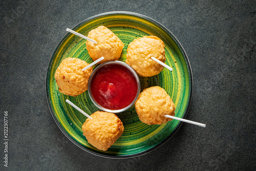 Photography Delightful snack balls served with tangy dipping sauce on a vibrant plate