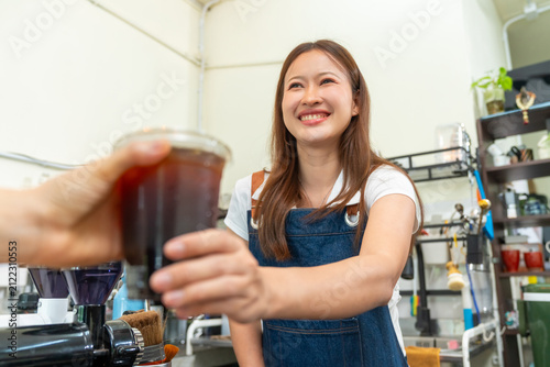 Fotografía Female barista serving fresh iced coffee to customer at cafe counter, profession