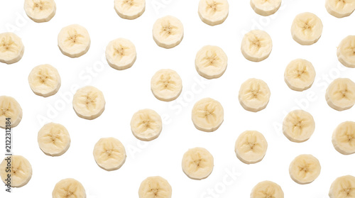 Many round slices of fresh yellow banana fruit arranged in a repeating pattern on a clean white background, creating a vibrant and healthy food texture.