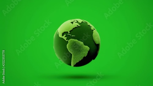 Spinning green earth globe rotating slowly with subtle shadow in studio lighting conceptualizing global business