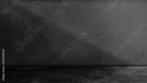 Dark black concrete studio room background with floor and wall illuminated by diagonal light beam ray spotlight shadow effect abstract interior texture for product presentation display mockup.