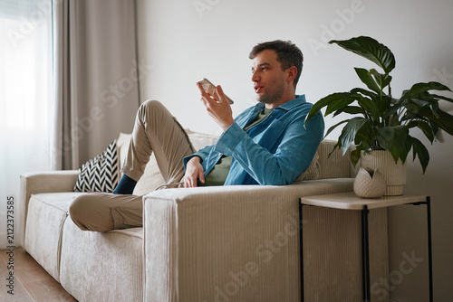 Man Sending Voice Message on Smartphone at Home