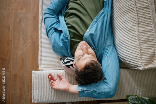 Man Relaxing on Sofa at Home Practicing Mindfulness