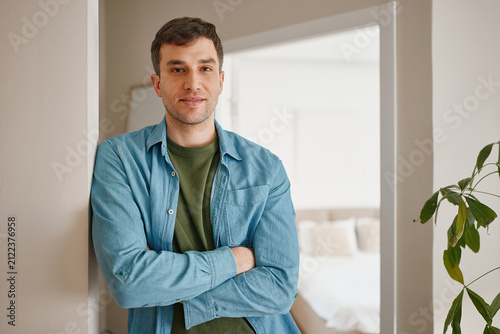 Portrait of a man standing in his modern apartment