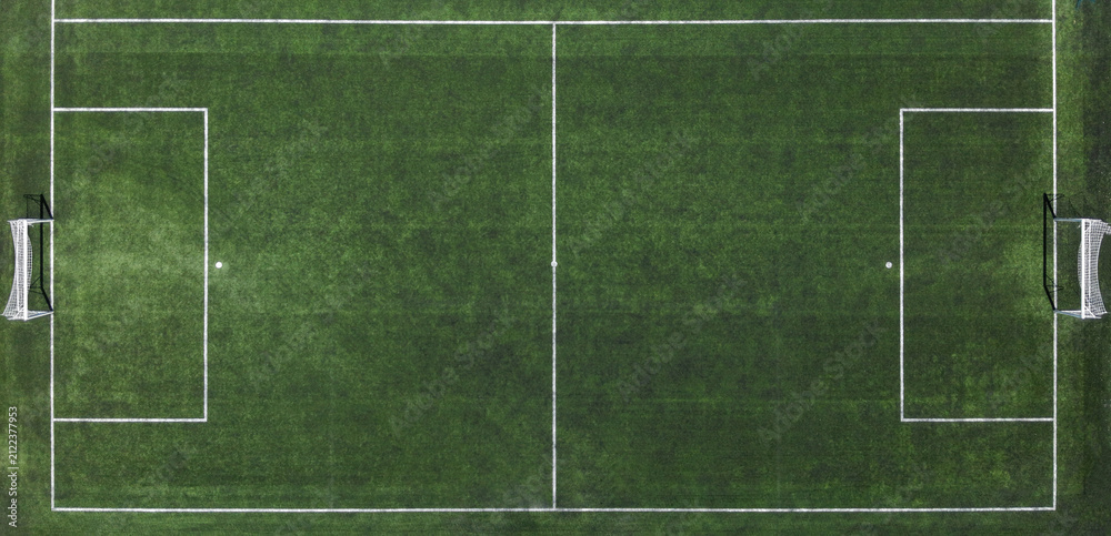 Naklejka premium Top down aerial drone view of a soccer football pitch with green turf and white field lines