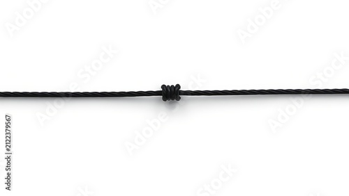 A single slender black rope resting on a simple surface, symbolizing strength.