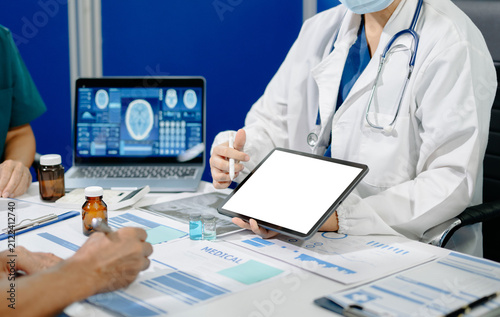 Asian medical team reviews clinical data, medication samples and digital reports during a healthcare meeting, highlighting collaboration, research and medical innovation.