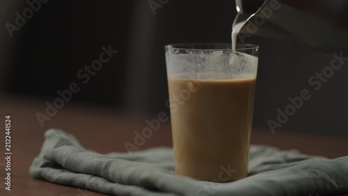 Slow motion making ice latte at home closeup shot