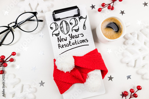 New year resolutions 2027 on desk. 2027 goals list with notebook, coffee cup on white table. Resolutions, plan, goals, action, checklist, idea concept. New Year 2027 resolutions, copy space