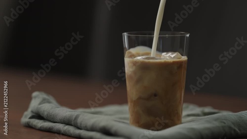 Slow motion making ice latte at home closeup shot