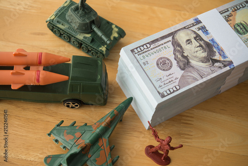 Foto US banknotes, army solider, combat aircraft fighter, tank, missile on wooden table