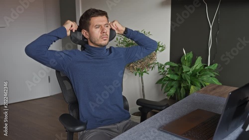 Man adjusting headrest on ergonomic office chair