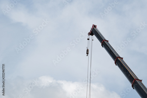 Closeup Mobile crane boom with wire ropes against blue sky 