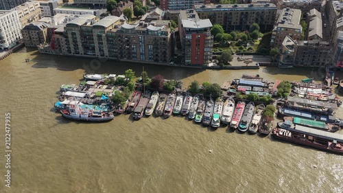 Narrowboats Docked Along the Thames River in London During a Sunny Summer Afternoon