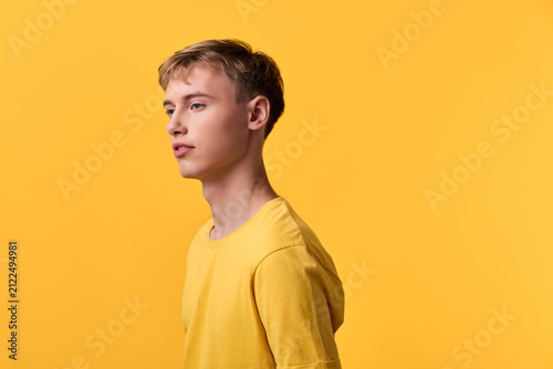 Yellow shirt male side profile in a studio setup, fashion orientated image with casual style, clean lines and minimal composition, emphasizing confidence and modern appeal for lifestyle, advertising