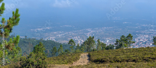 Bild auf Leinwand A scenic trail leads across a mountain ridge overlooking a wide valley town