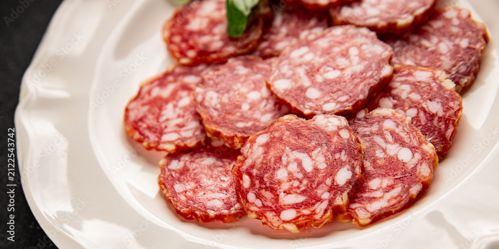 Obraz premium Sausage slices salami cured sausages meat food preparation dish tasty snack fresh and delicious gourmet rustic food background on the table rustic food top view copy space