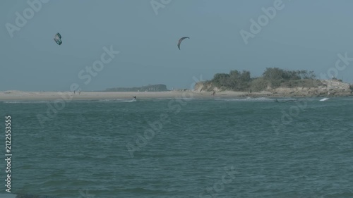 Slow Motion Kite Surfers Riding Waves Near Sandy Beach Sunshine