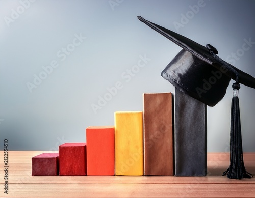 international higher education program for graduates showcasing a black graduation cap on a growing bar graph to depict students hard work towards future career goals
