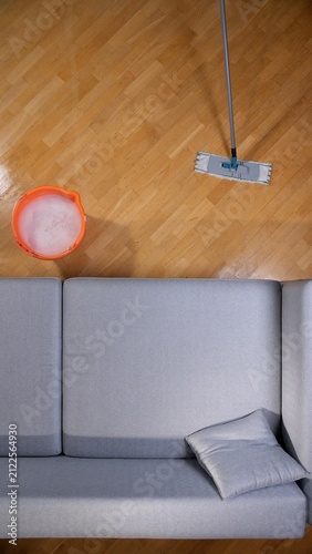 Fotografie Cleaning supplies featuring a bucket with soapy water and a flat mop on a shiny
