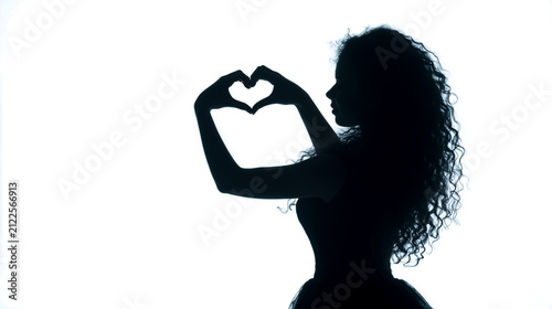 Silhouette of woman holding heart shape