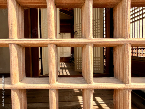 Obraz na płótnie Traditional Korean wooden lattice window revealing an interior with warm natural light, geometric patterns, and classic architectural details