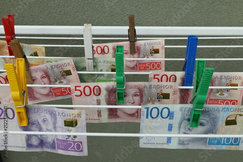 Laundering money concept. Hanging Swedish banknotes with clothespin to dry at laundry rack. DIY joke. 