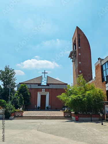 Wide view of the red brick Catholic church and bell tower of Beijing Catholic Theological Seminary in summer in Houbajia, Beijing, China