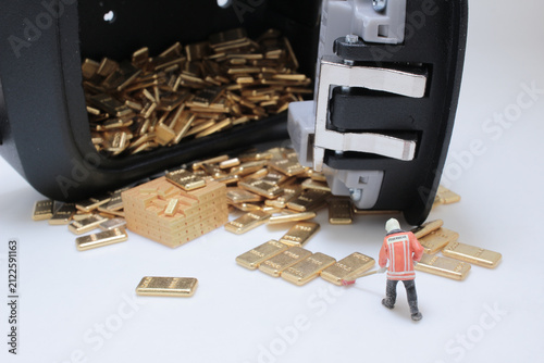 Foto Miniature firefighter cleaning gold bullion bars