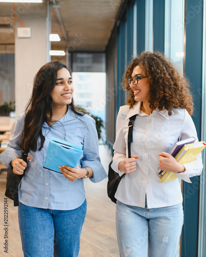Diverse female students walking and smiling on campus
