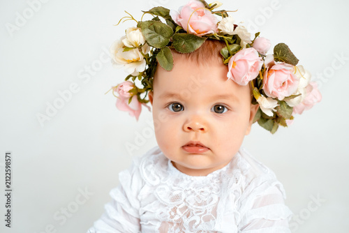 a little girl in a flower headband, a baby portrait on a white isolated background