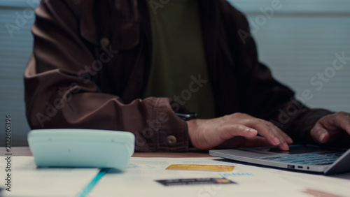 Person typing keyboard calculating budget checking credit card document desk workspace finance accounting banking payment loan economy corporate strategy market profit revenue cost expense task job.