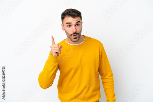 Young caucasian man isolated on white background intending to realizes the solution while lifting a finger up