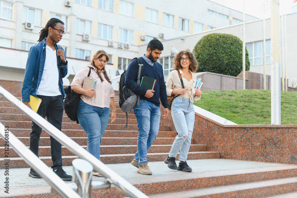 Obraz premium Diverse students walking down university stairs outdoors